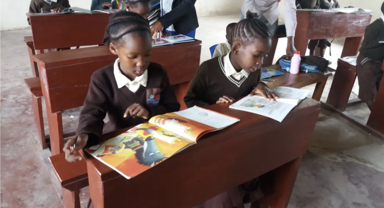 Two girls reading books from Darien Book Aid